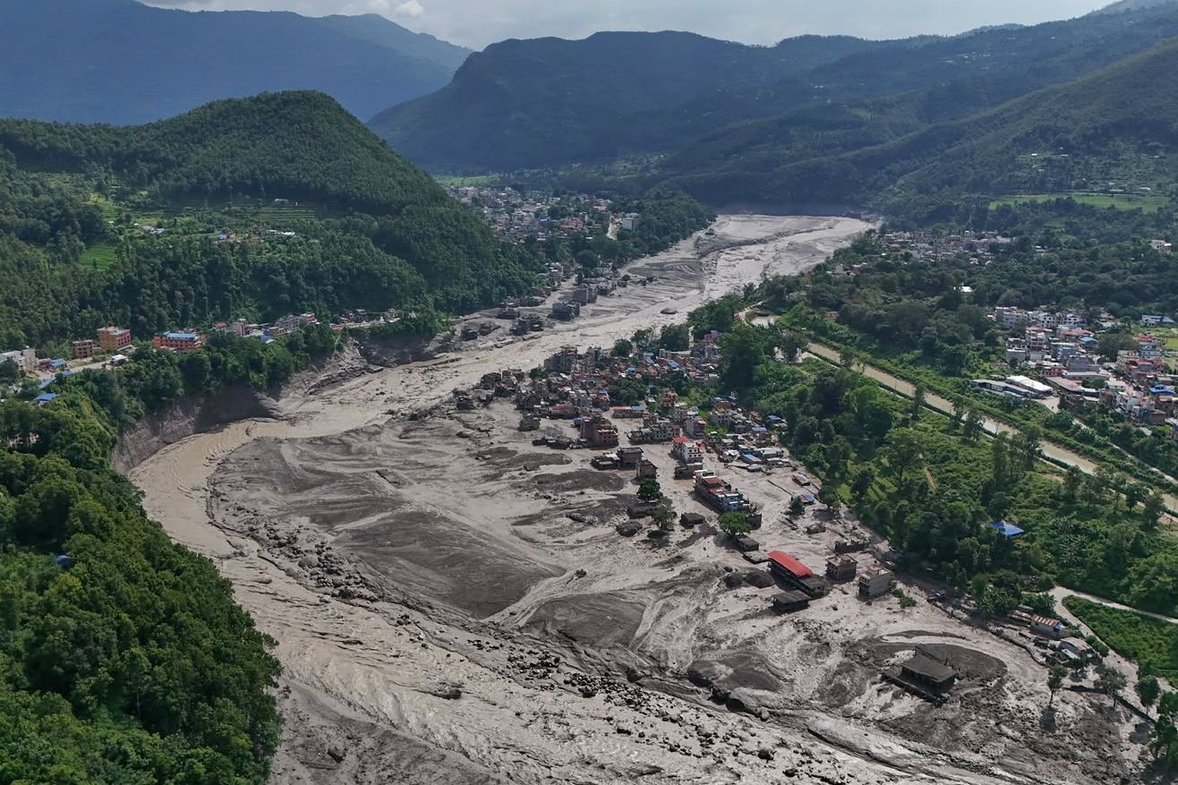 Záchranáři a místní obyvatelé v zasažené oblasti po povodních